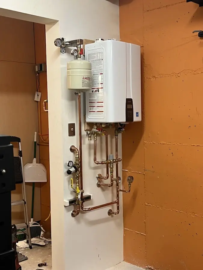 Plumbing technician inspecting water heater connections in Bloomington